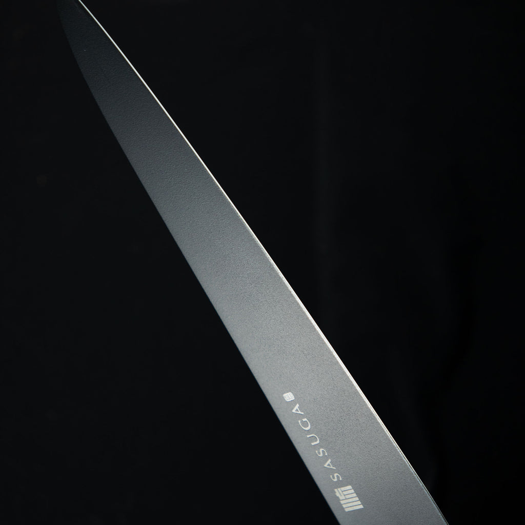 Close-up of a knife blade with 'SASUGA' branding on a black background