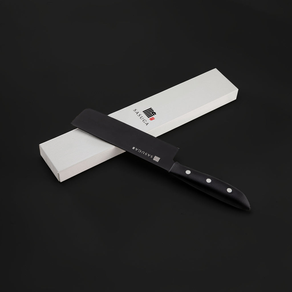 Black ceramic knife with a black sheath on a white box against a dark background