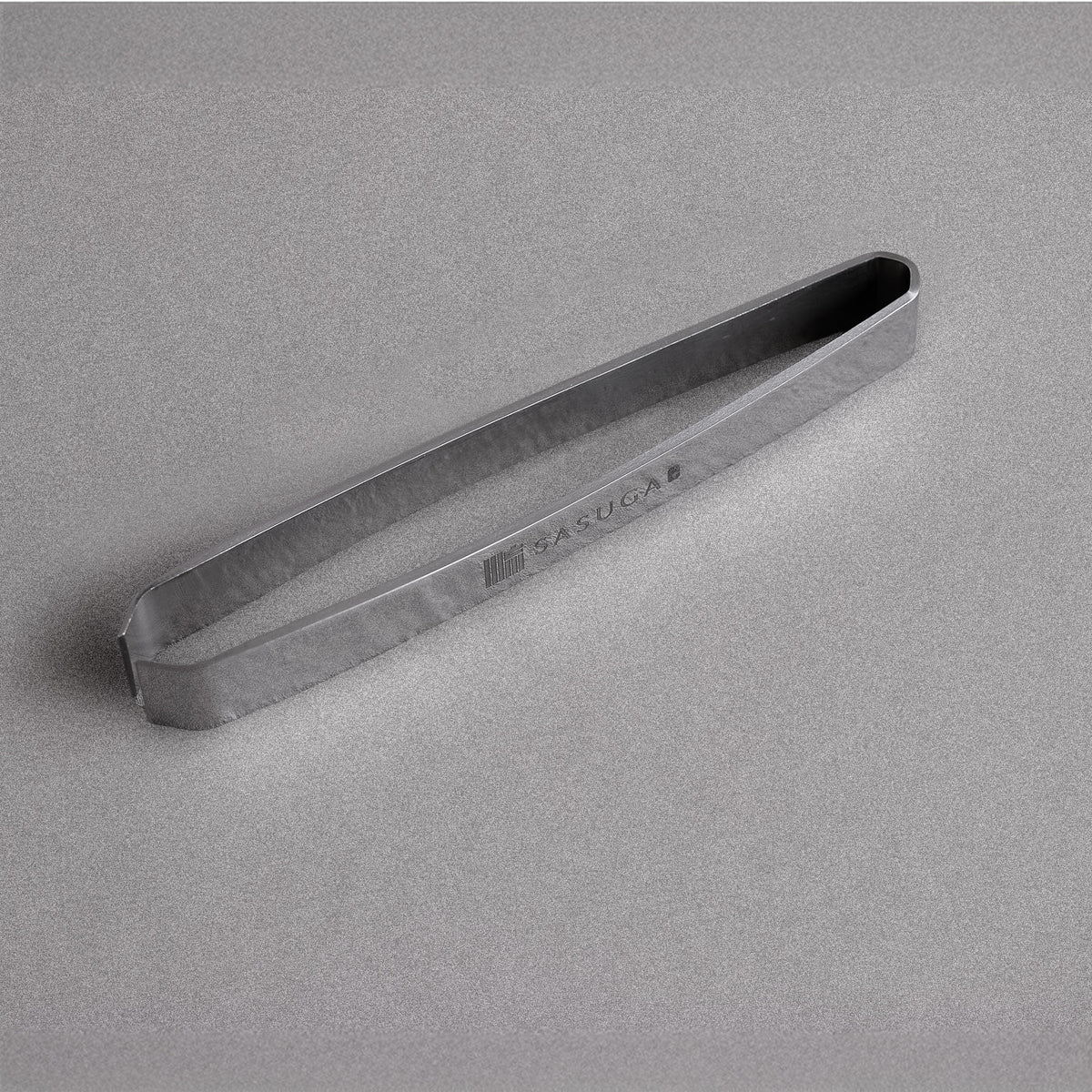 Stainless steel fish bone tweezers on a gray background